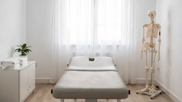 Osteopathische Praxis mit Behandlungsliege und Anatomiemodell zum Thema Selbstheilung in der Osteopathie