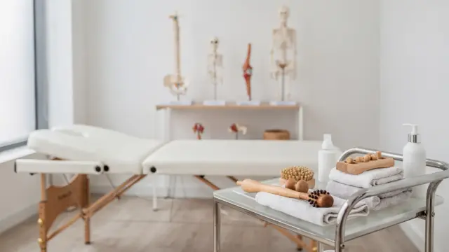 Osteopathie bei akuten Entzündungen: Behandlungsraum mit Liege und anatomischen Modellen