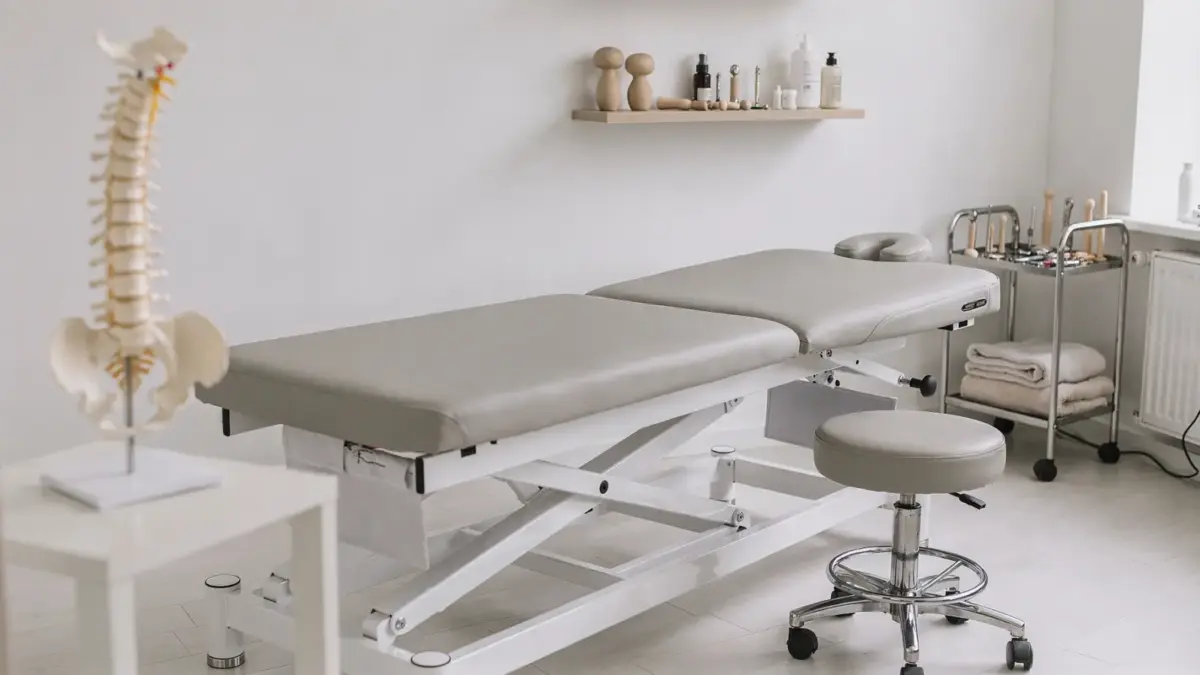 Osteopathie-Techniken in einer Praxis mit Behandlungsliege und Wirbelsäulenmodell