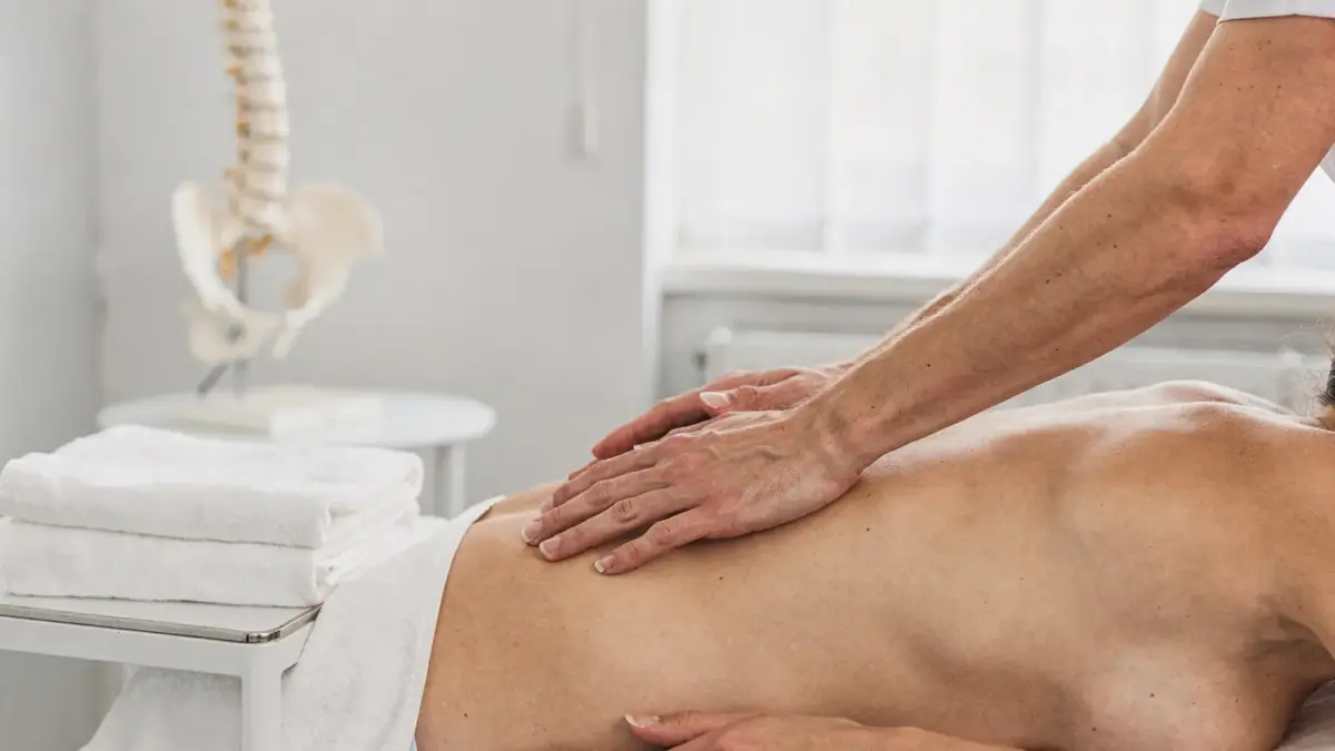 Manuelle Therapie in der Osteopathie: Behandlungstisch, Anatomiemodell und Hände bei der Behandlung