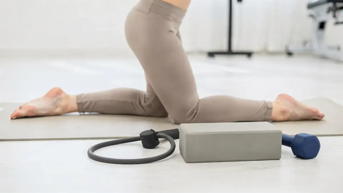 Übungen bei Hüftschmerzen: Matte, Widerstandsband und Hüftmobilisationsübung in einer Physiotherapie-Szene