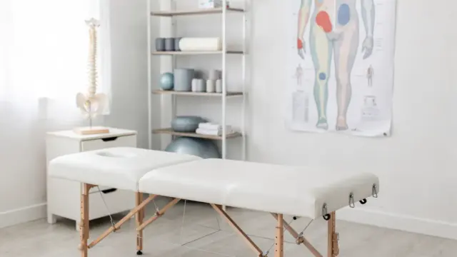 Pädiatrische Osteopathie bei Haltungsproblemen: Behandlungsliege, Wirbelsäulenmodell und Haltungskarte im Therapieraum