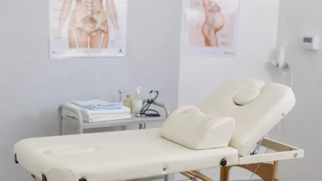 Schwangere Frau bei osteopathischer Behandlung in heller Praxis zum Thema Schwangerschaftsbeschwerden