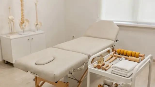 Osteopathische Praxis mit Behandlungsliege und Anatomiemodell zum Thema Grundprinzipien der Osteopathie