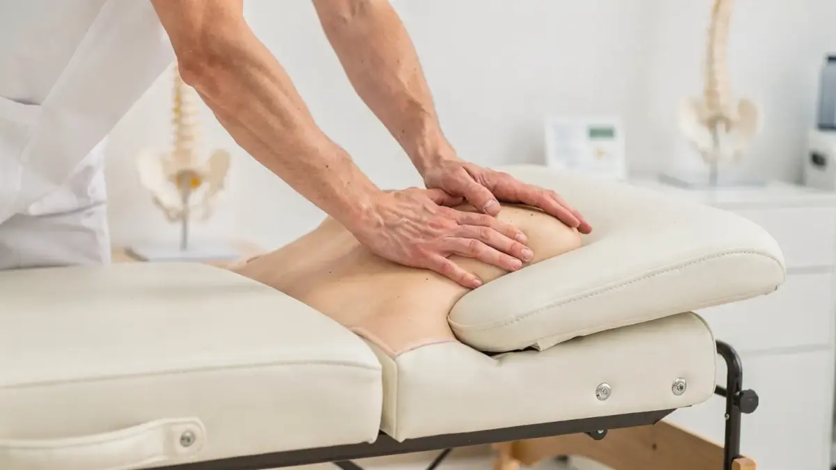 Osteopathie: Behandlungstisch, Wirbelsäulenmodell und manuelle Technik im Therapieraum