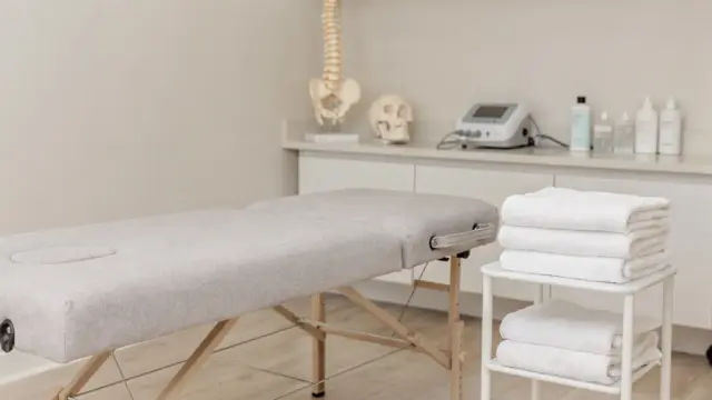 Osteopathische Behandlung: Behandlungsraum mit Liege und anatomischem Modell