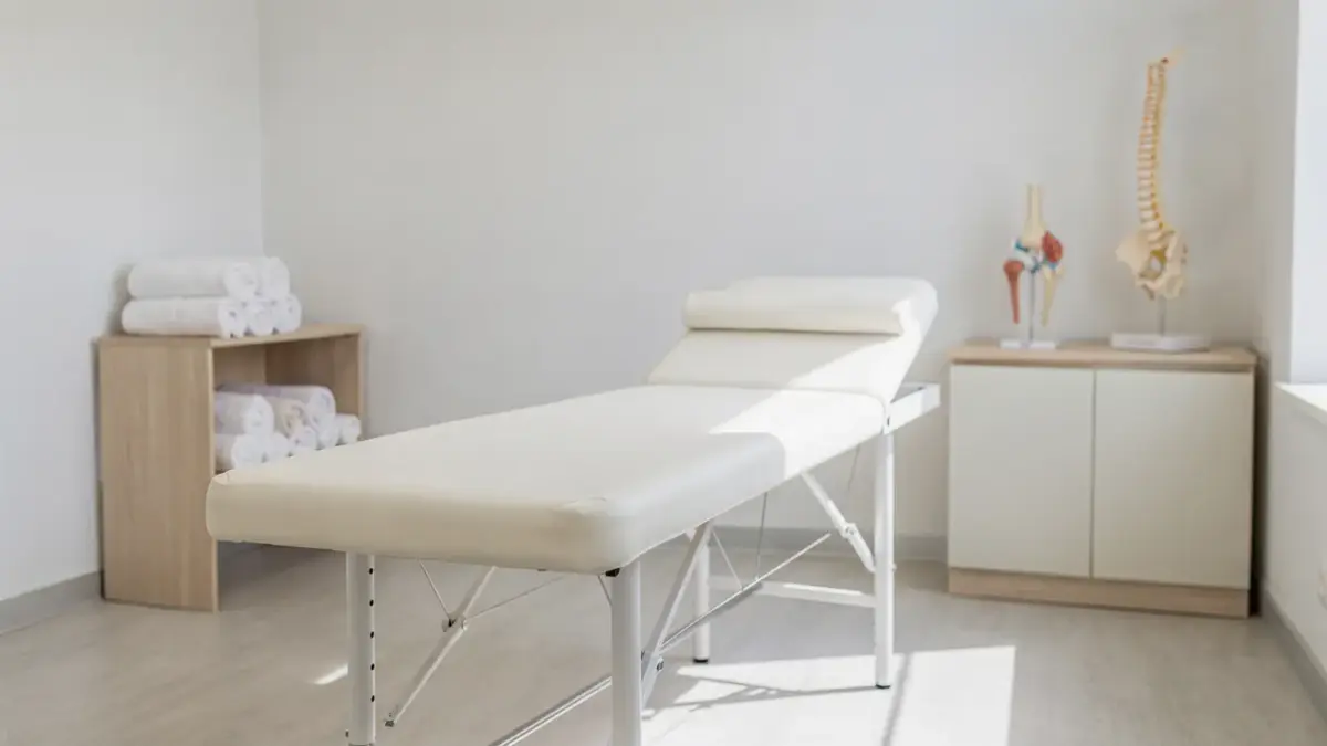 Osteopathie-Risiken: Behandlungsraum mit Liege, Handtüchern und Anatomiemodell